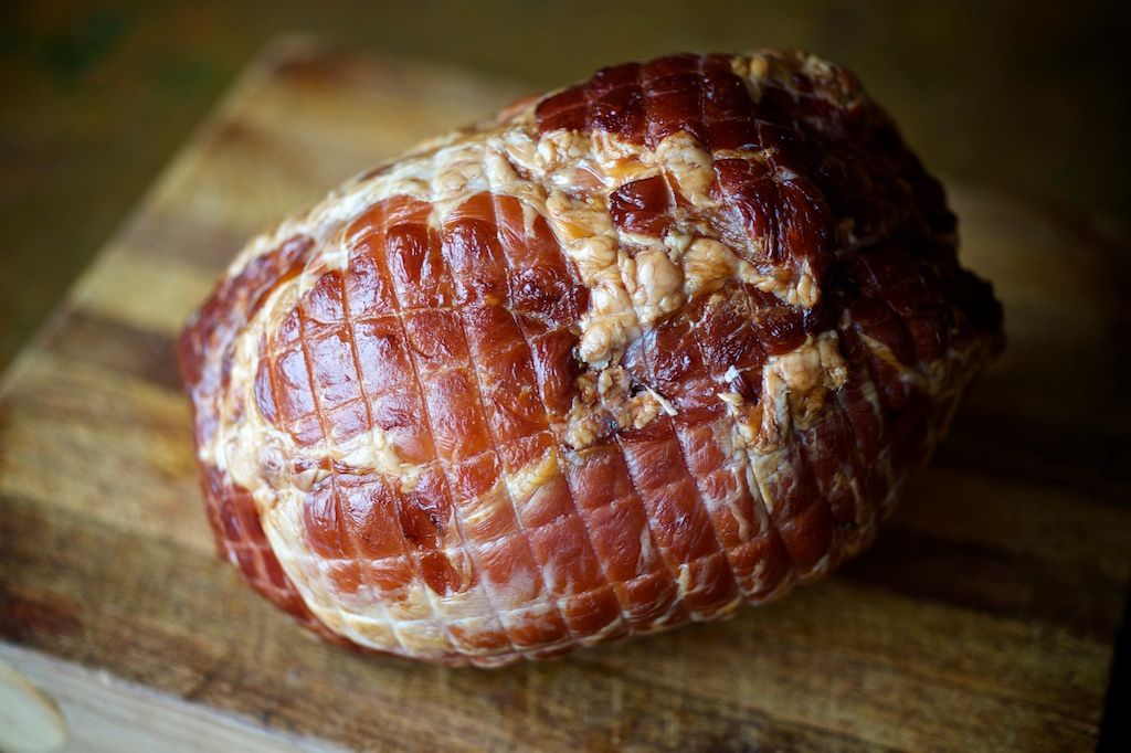 whole ham on a wood board